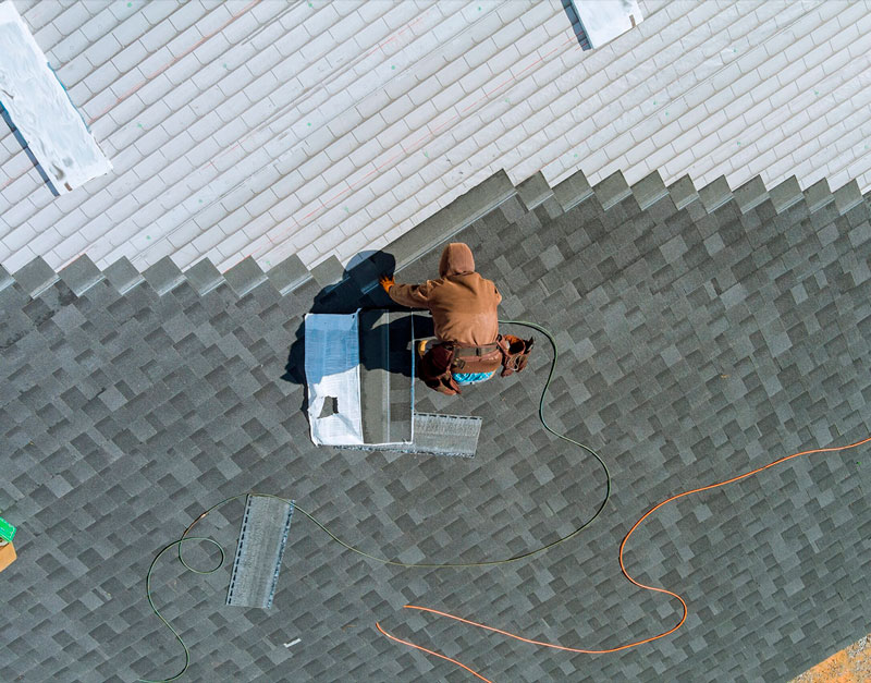 Roofer working on a ridge vent installation viewed from above.